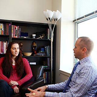 Rev. Todd Boling of TCU Religious and Spiritual Life talks to a student in his office.