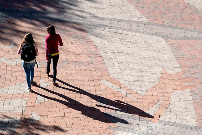 Two students walking through the Campus Commons